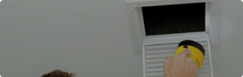 HVAC technician inspecting air duct