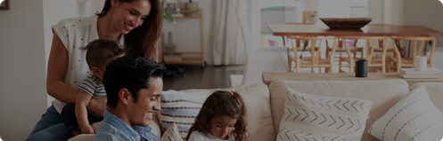 Happy family sitting on couch with parents and young children